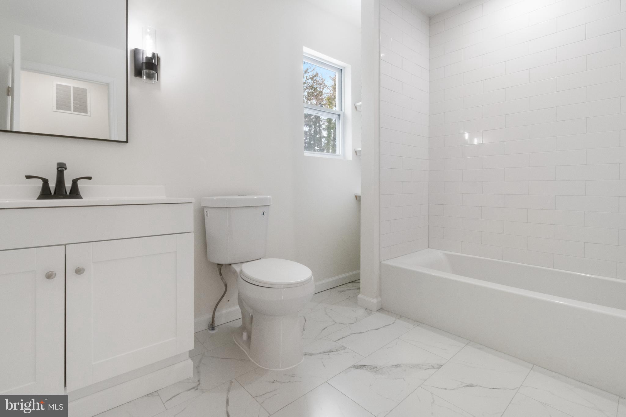 119 Hemlock Avenue Laurel Springs, NJ 08021 - Photo 22 of 23 a bathroom with a toilet a sink a mirror and vanity