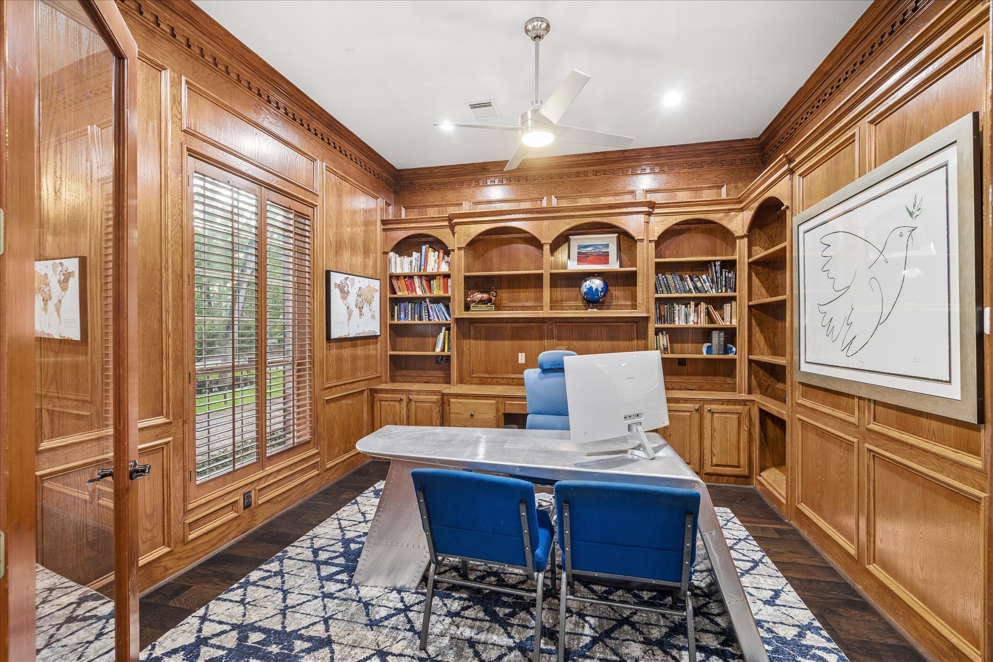 35 North Regent Oak Spring, TX 77381 - Photo 7 of 43 An exceptional executive study showcases exquisite floor-to-ceiling wood paneling, rich hardwood floors, custom built-in cabinetry, and refined craftsmanship at every turn. Thoughtfully designed to provide both elegance and functionality, this distinguished space offers the ideal setting for a private office, library, or executive retreat. Large windows invite natural light and peaceful views of the surrounding landscape.