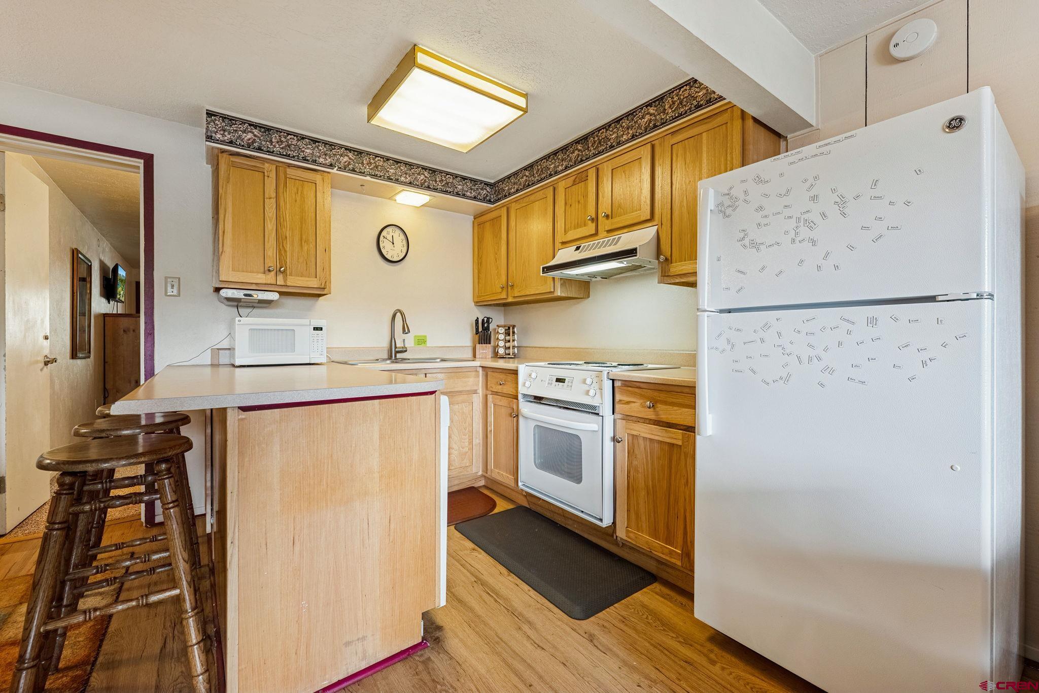 400 Sheol Street, Unit 7 Durango, CO 81301 - Photo 11 of 35 a kitchen with a refrigerator a sink and wooden floor