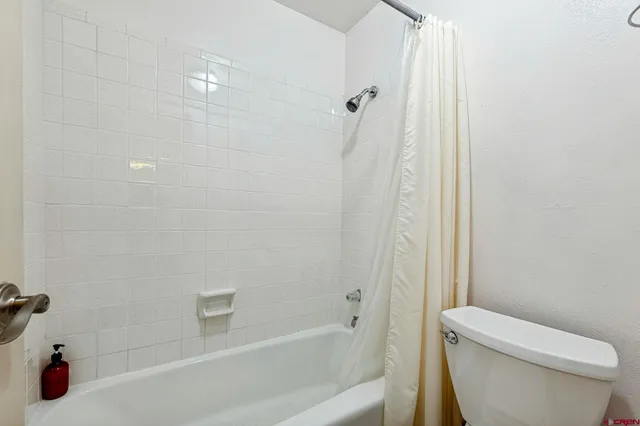 a white bath tub sitting next to a white toilet and sink