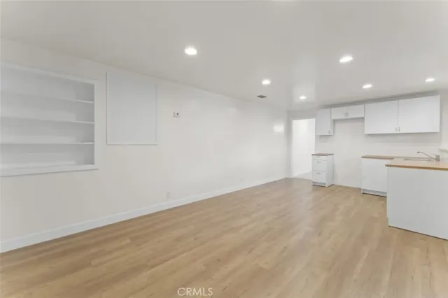 a view of a kitchen with white cabinets and wooden floor