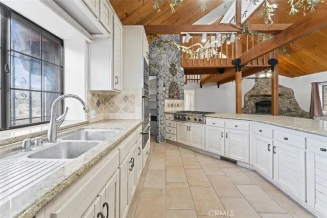 a kitchen with stainless steel appliances granite countertop a sink a stove and cabinets