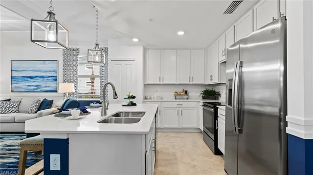 a kitchen with stainless steel appliances a sink a stove a refrigerator and cabinets