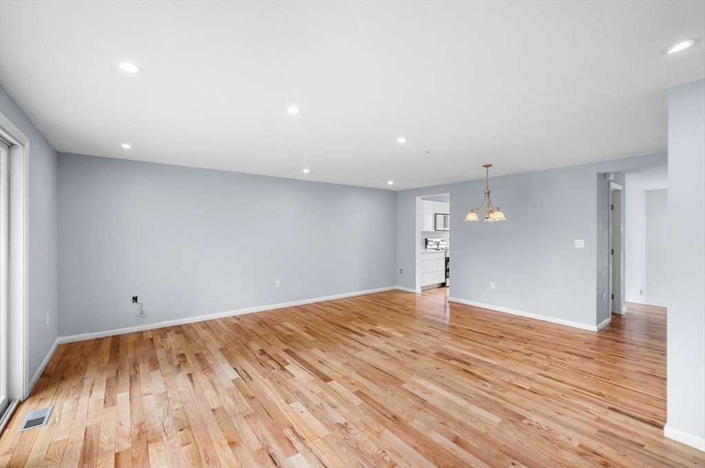 45 Abington Road, Unit 45 Danvers, MA 01923 - Photo 11 of 35 a view of an empty room with wooden floor and a window