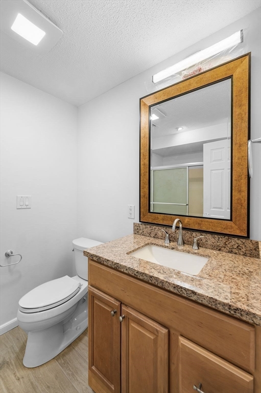 45 Abington Road, Unit 45 Danvers, MA 01923 - Photo 24 of 35 a bathroom with a granite countertop toilet a sink and mirror