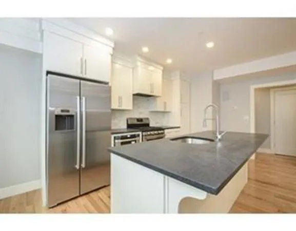 a kitchen with kitchen island a counter top space cabinets stainless steel appliances and a counter space