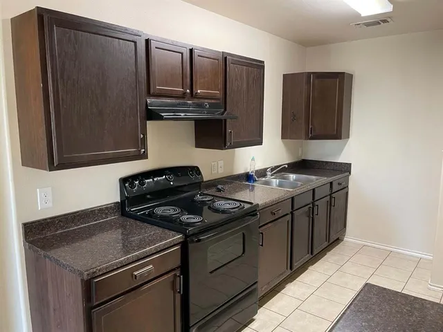 a kitchen with stainless steel appliances granite countertop a stove and a microwave