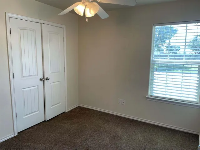 an empty room with windows and closet