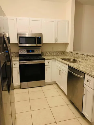 a kitchen with granite countertop a stove and a microwave