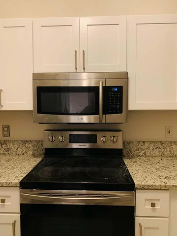 a kitchen with a stove and a white cabinets