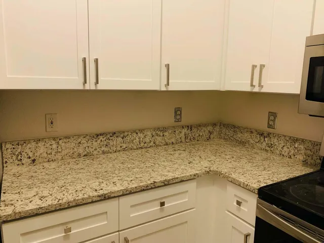 a view of an empty room and chandelier fan
