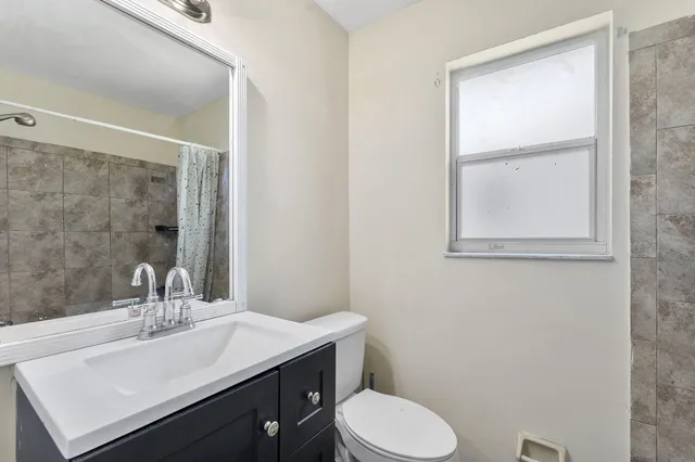 a bathroom with a sink a toilet and mirror