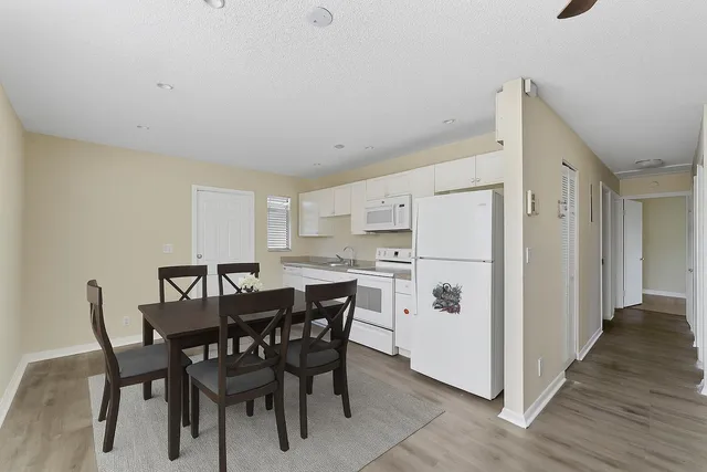 a view of dining room and kitchen with a table chairs and a refrigerator