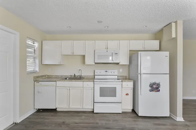 a kitchen with white cabinets and white appliances