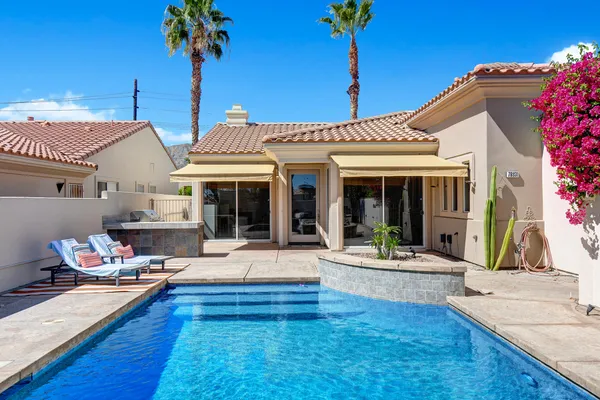 a view of a house with swimming pool and sitting area