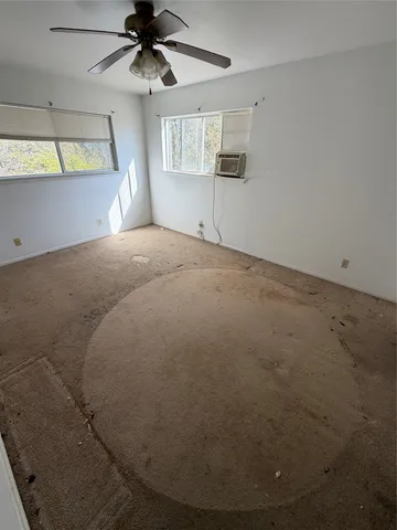 a view of a livingroom with a ceiling fan and window