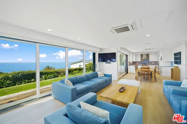 a living room with furniture and a floor to ceiling window