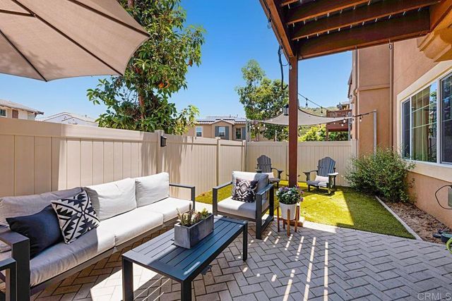 a view of a backyard with chair and potted plants