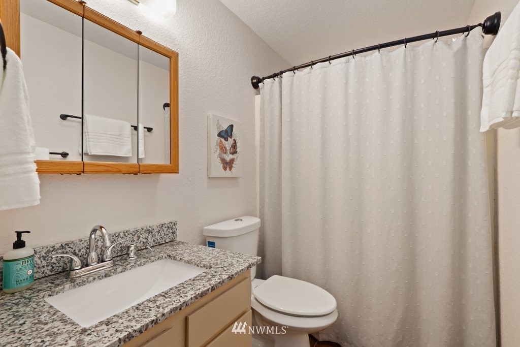 18216 19th Drive Southeast Bothell, WA 98012 - Photo 11 of 37 a bathroom with a granite countertop sink and a mirror