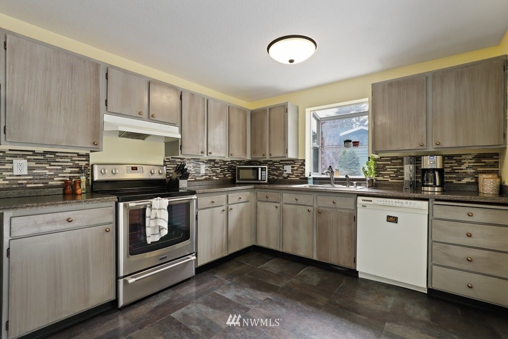 18216 19th Drive Southeast Bothell, WA 98012 - Photo 7 of 37 a kitchen with granite countertop a sink cabinets and stainless steel appliances