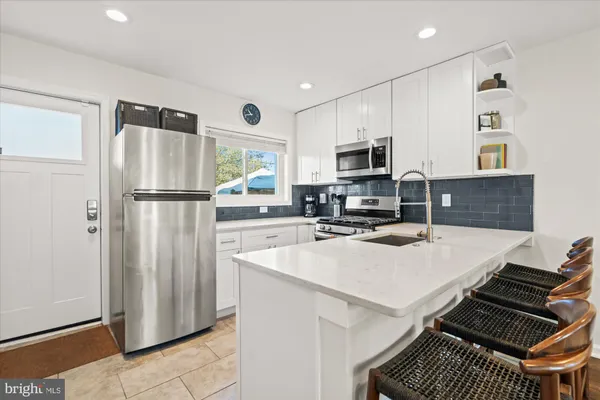 a kitchen with a refrigerator and a stove top oven