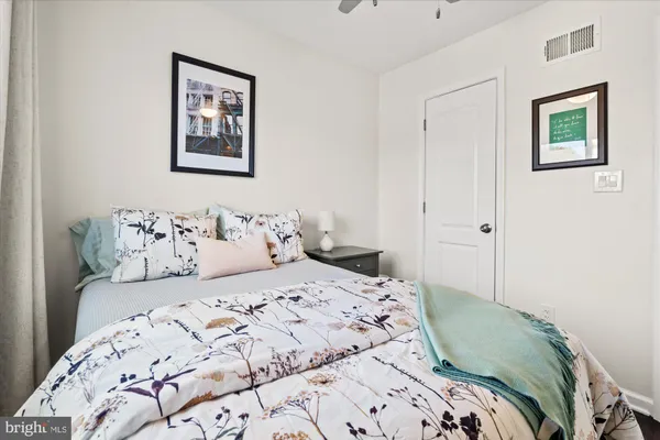 a bedroom with a bed and a painting on the wall