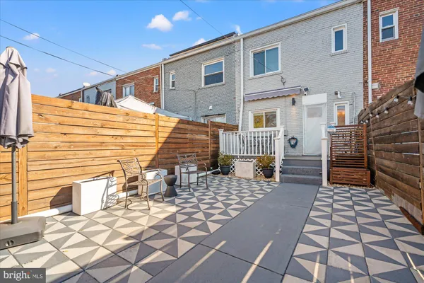 a backyard of a house with barbeque oven and glass door