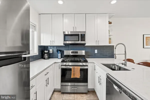 a kitchen with granite countertop a stove a sink and a microwave