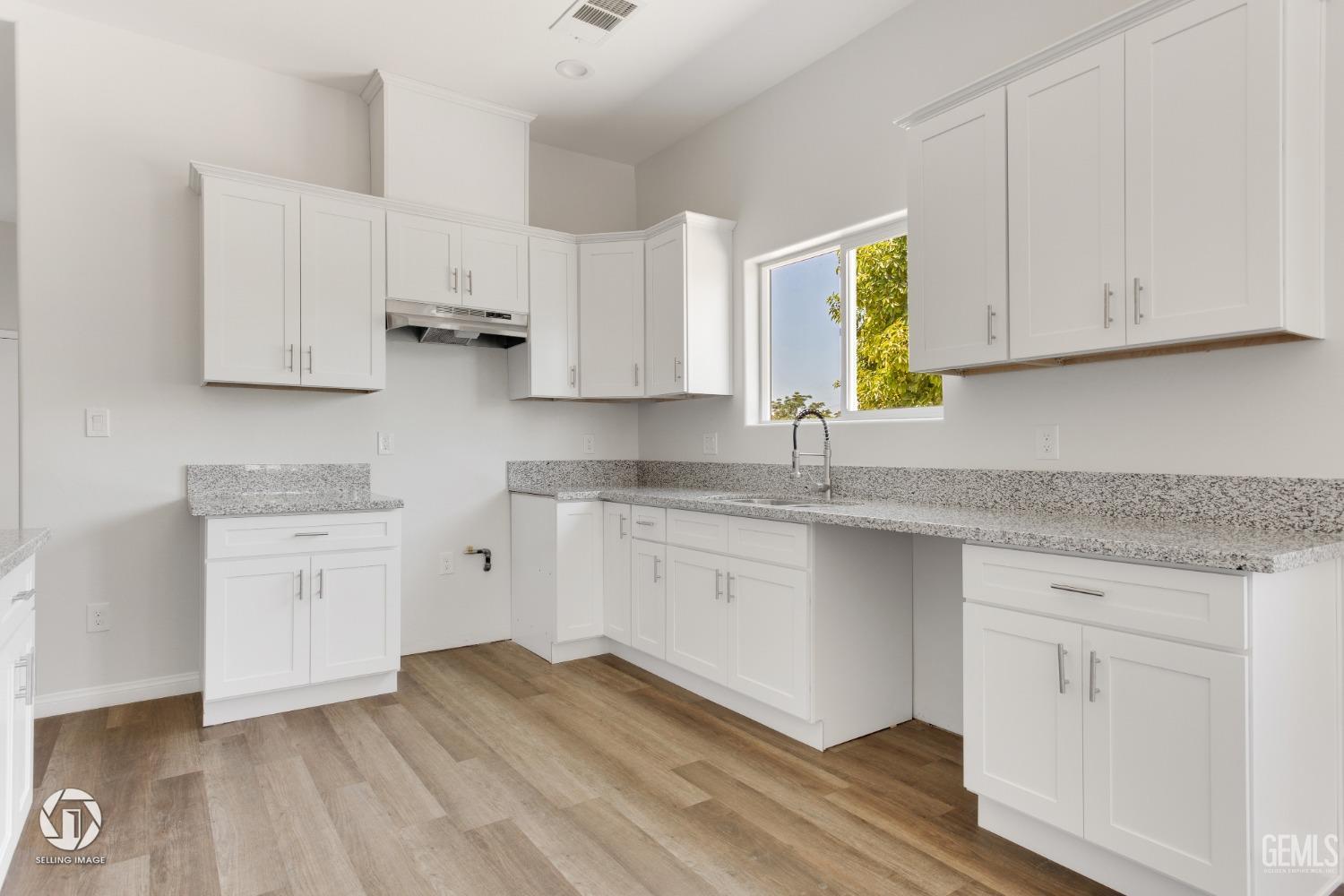 Undisclosed Address Bakersfield, CA 93305 - Photo 11 of 28 a kitchen with granite countertop white cabinets white appliances and granite counter tops