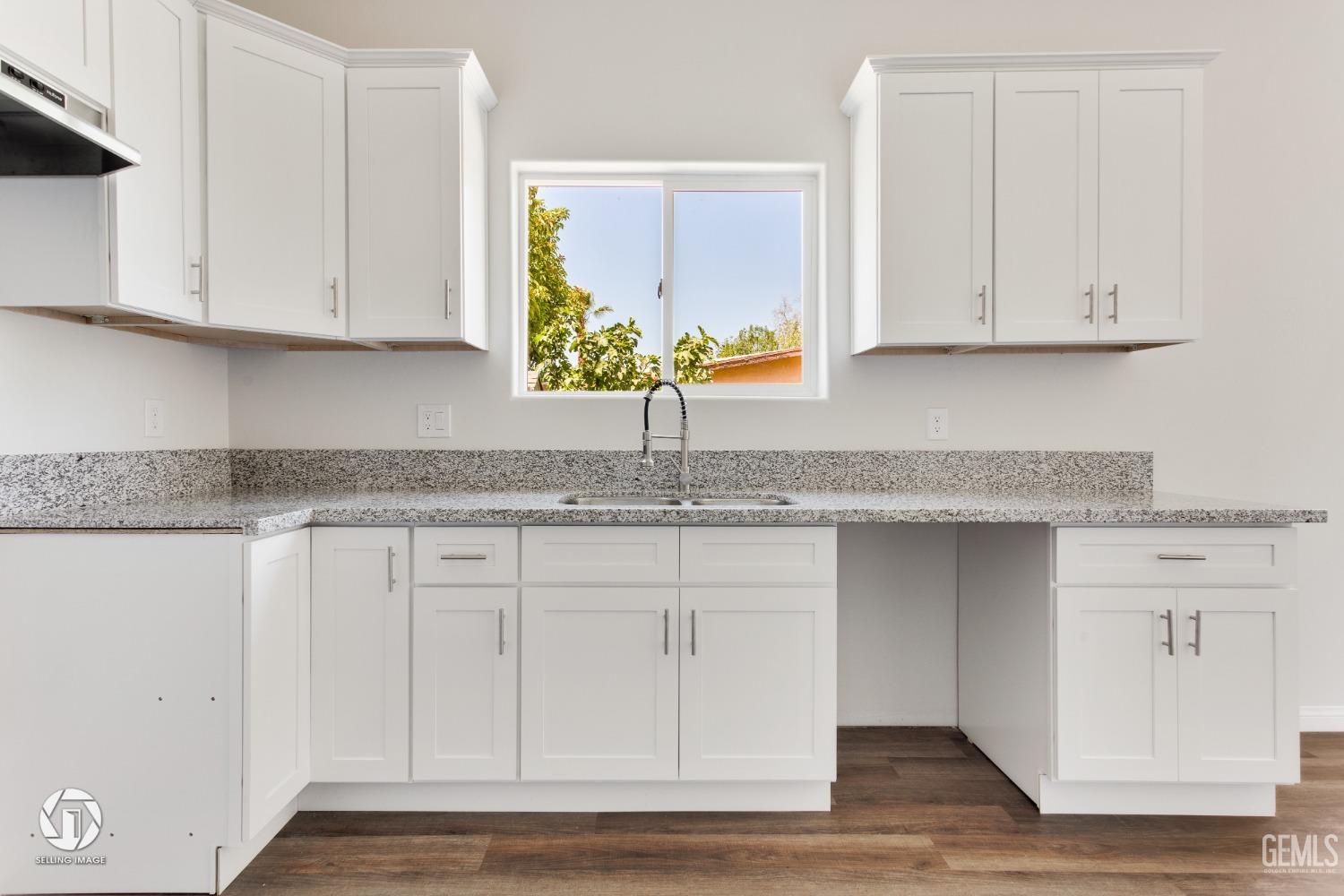 Undisclosed Address Bakersfield, CA 93305 - Photo 12 of 28 a kitchen with granite countertop white cabinets and a sink