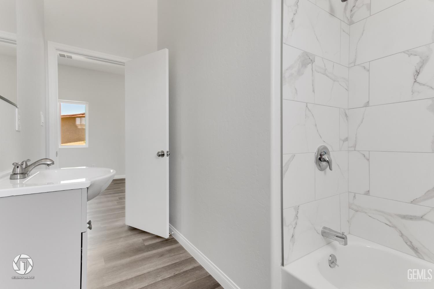Undisclosed Address Bakersfield, CA 93305 - Photo 18 of 28 a bathroom with a bathtub a sink and wooden floor