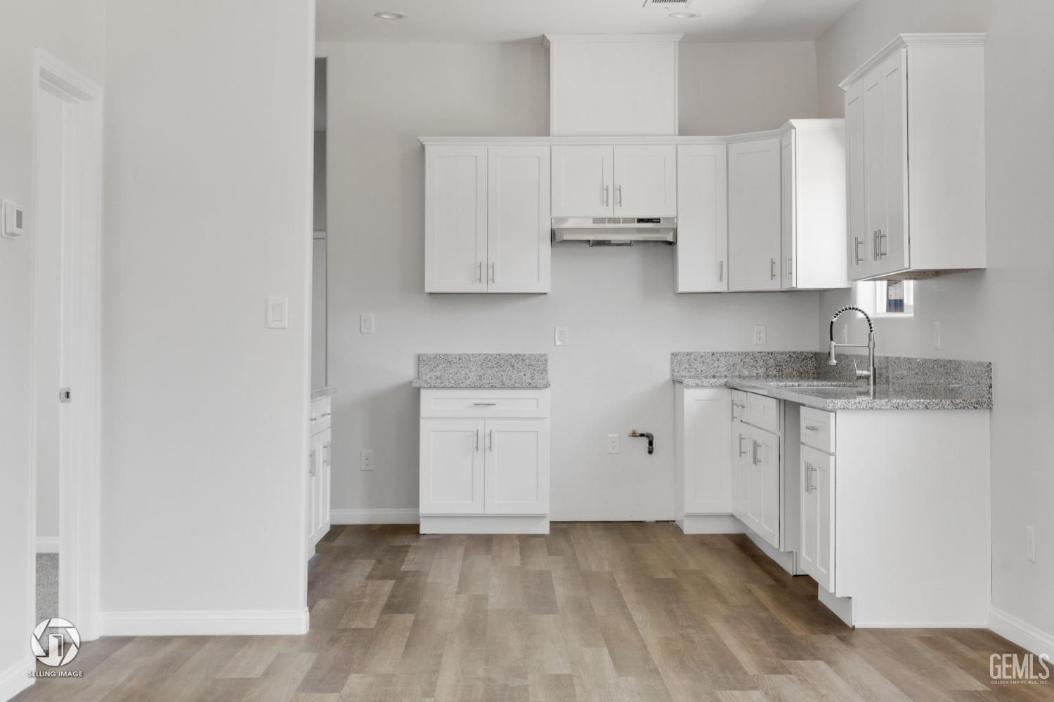 Undisclosed Address Bakersfield, CA 93305 - Photo 9 of 28 a kitchen with white cabinets and white appliances