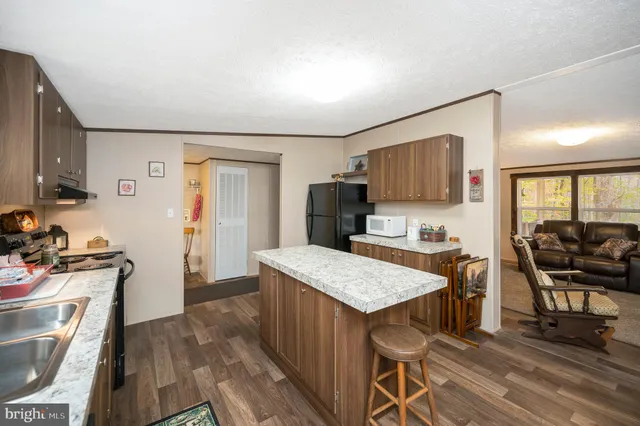 a kitchen with a stove a refrigerator and wooden floor