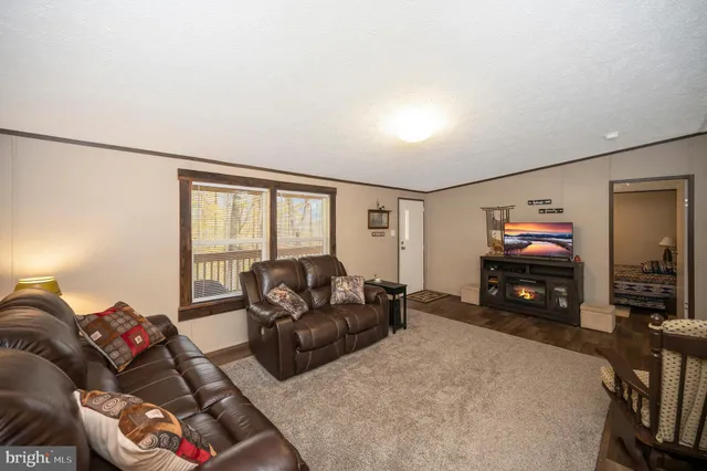 a living room with furniture a large window and a flat screen tv