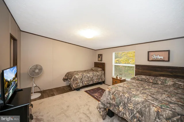 a bedroom with a bed and painting on the wall