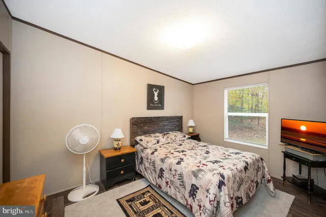 a bedroom with a bed and a tv on table
