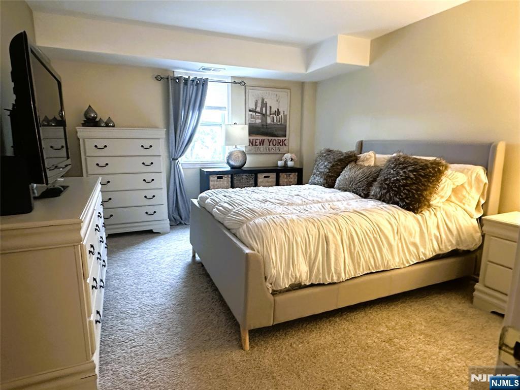 39 Union Street, Unit 105 Hackensack, NJ 07601 - Photo 12 of 22 a bedroom with a bed and a flat tv screen