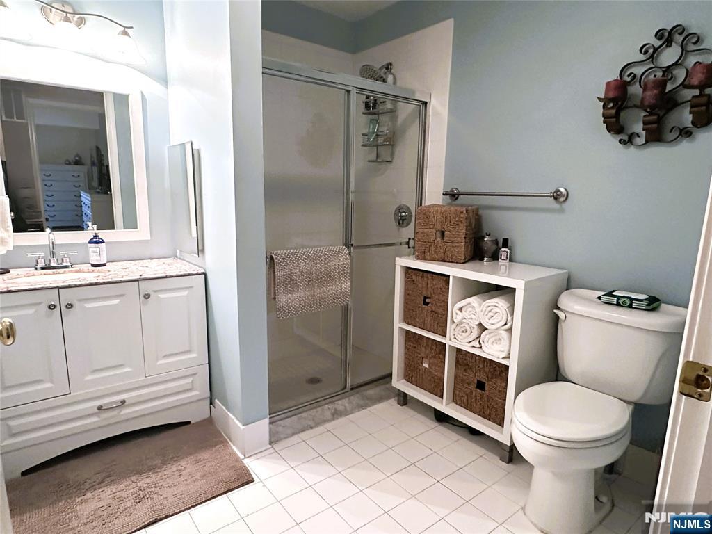 39 Union Street, Unit 105 Hackensack, NJ 07601 - Photo 8 of 22 a bathroom with a toilet a sink and glass door