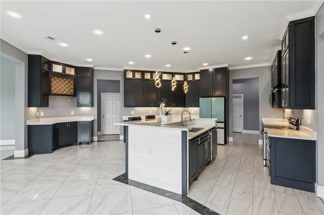 a large kitchen with a large counter top sink stainless steel appliances and cabinets