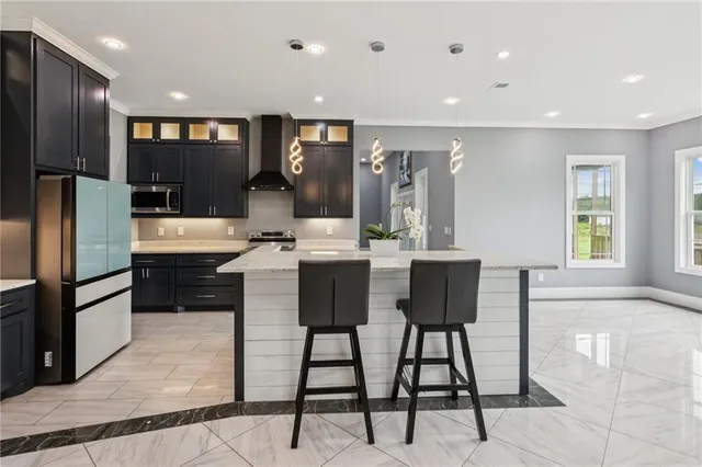 a kitchen with stainless steel appliances kitchen island granite countertop a refrigerator and a stove top oven