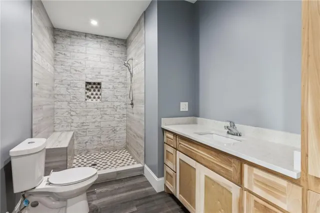 a view of a stone house with a yard and large tree