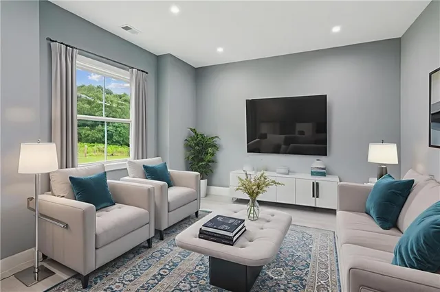 a living room with furniture a flat screen tv and a large window
