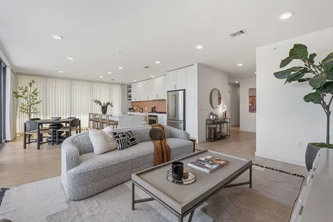 a living room with furniture kitchen view and a table