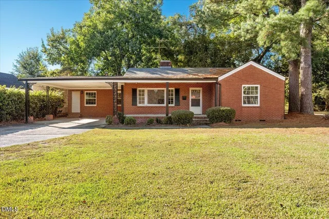 a front view of house with yard and trees around