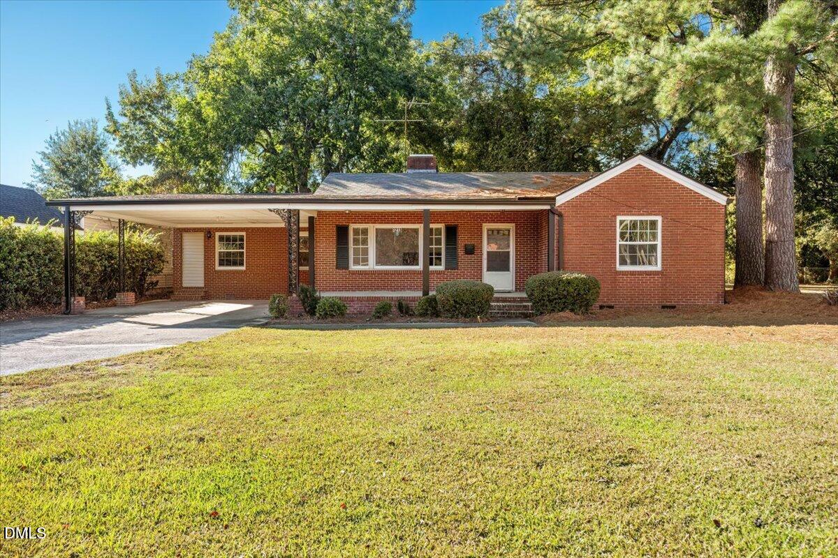 1213 Tarboro Street Southwest Wilson, NC 27893 - Photo 1 of 27 a front view of house with yard and trees around