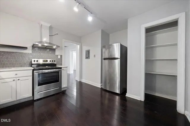 a kitchen with a refrigerator and a stove top oven