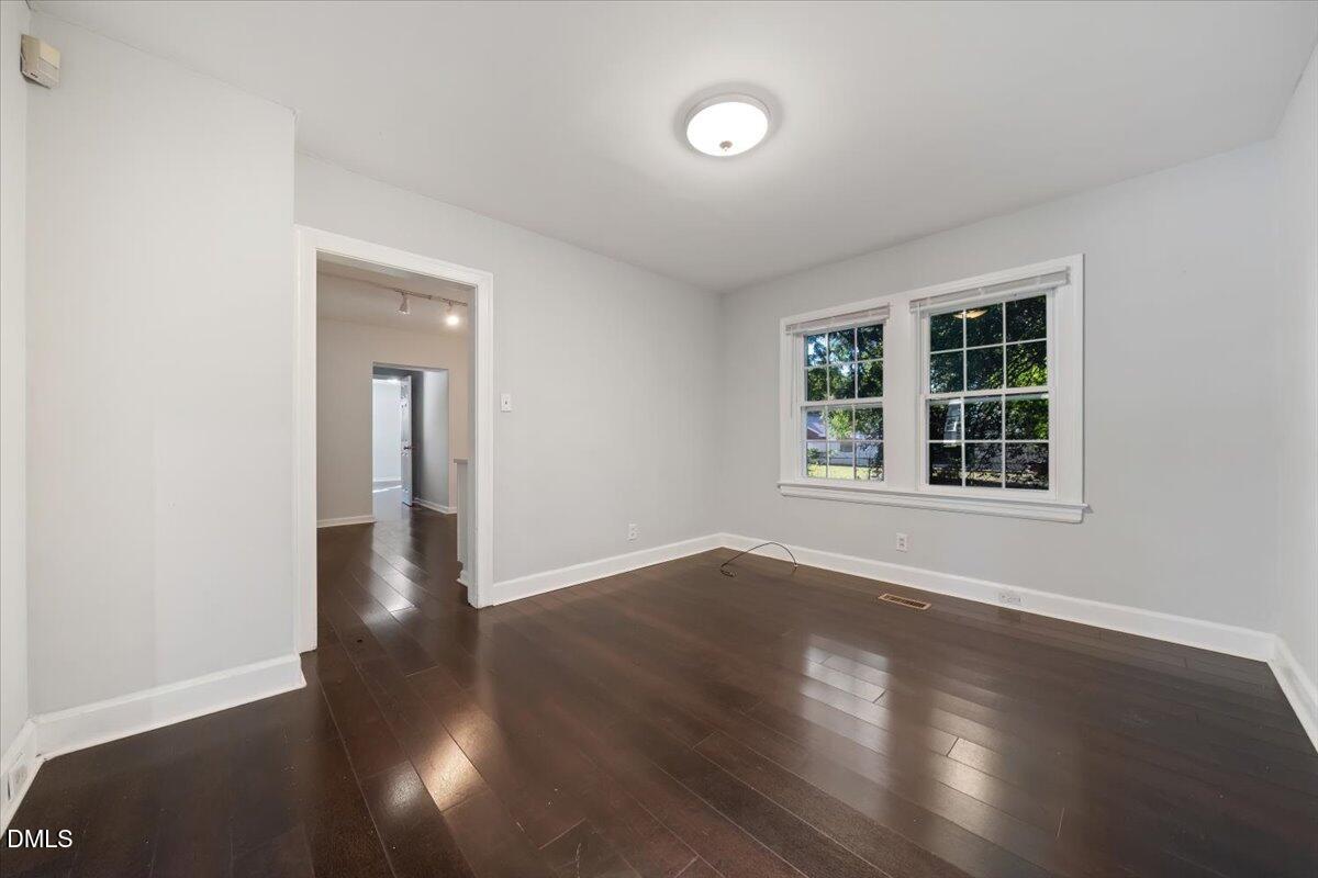 1213 Tarboro Street Southwest Wilson, NC 27893 - Photo 21 of 27 a view of an empty room with wooden floor and a window