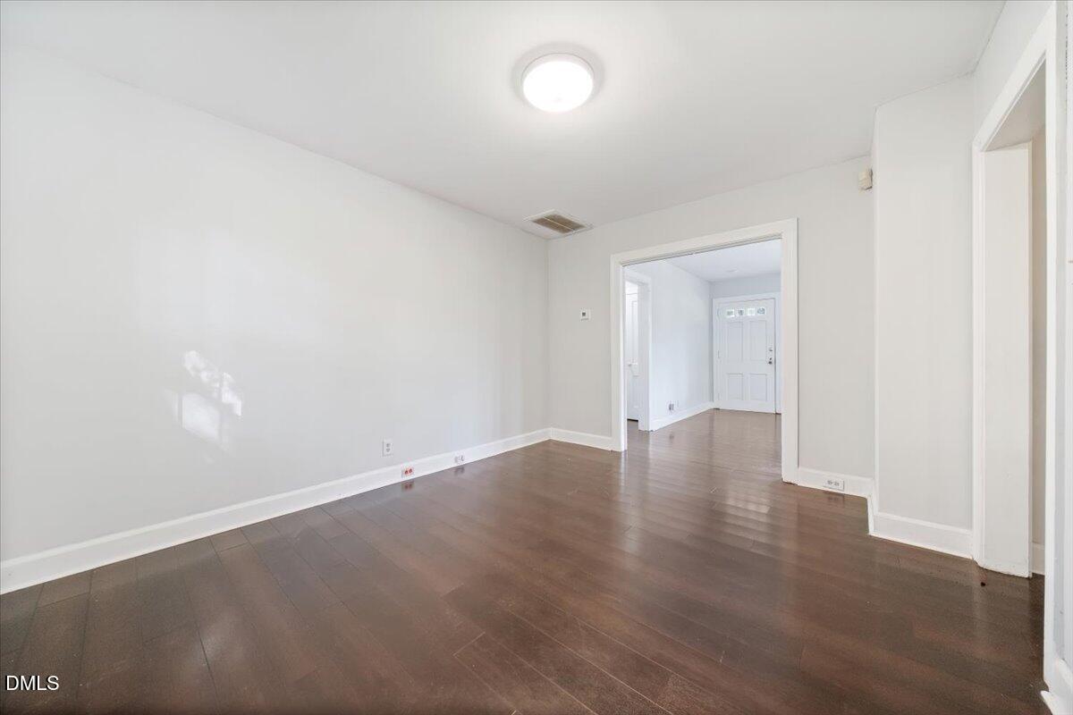 1213 Tarboro Street Southwest Wilson, NC 27893 - Photo 22 of 27 an empty room with wooden floor and windows