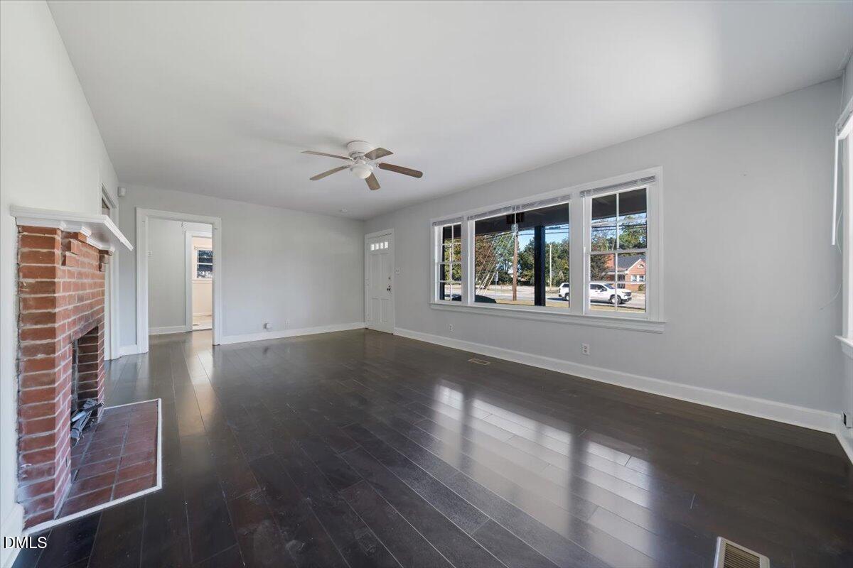1213 Tarboro Street Southwest Wilson, NC 27893 - Photo 7 of 27 an empty room with wooden floor and windows