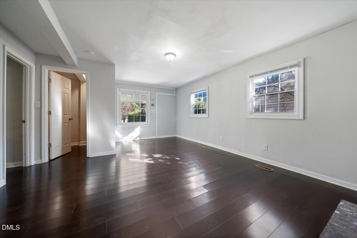 1213 Tarboro Street Southwest Wilson, NC 27893 - Photo 8 of 27 a view of an empty room with wooden floor and a window